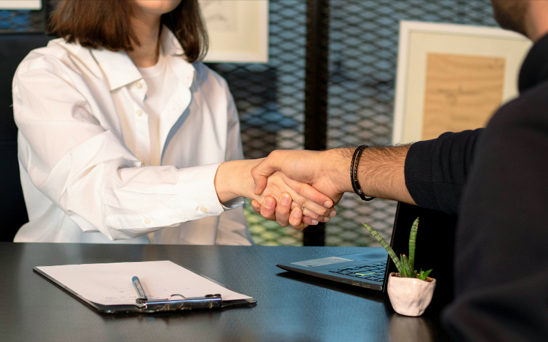 A photo of two people shaking hands at a job interview.