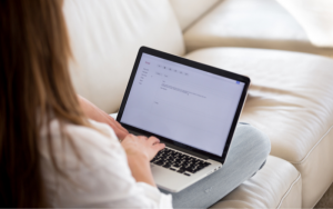 Stock image of girl on laptop on a sofa