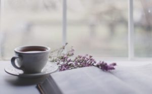 A white mug, a book and some lavender.