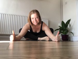 Yoga teacher Emma poses with her thumbs up