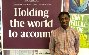 NCTJ-accredited journalist Shingi is standing in front of a Sunday Times banner which reads "Holding the world to account"