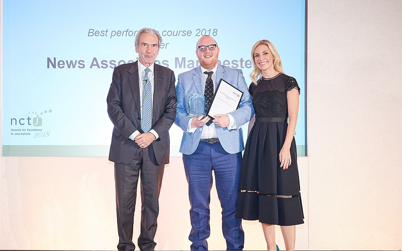 Andrew Greaves collecting the award for top NCTJ journalism school and fast-track course in 2018. He's standing with NCTJ chairman Kim Fletcher and Sky News presenter Sarah Hewson. They're all dressed up very smart with big smiles.
