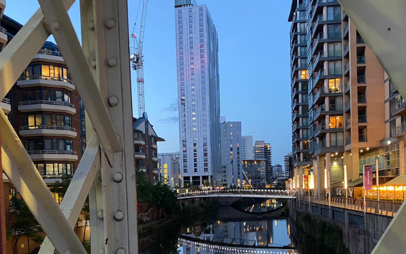 Photo of Manchester buildings along the canal, with lights reflecting on the water.