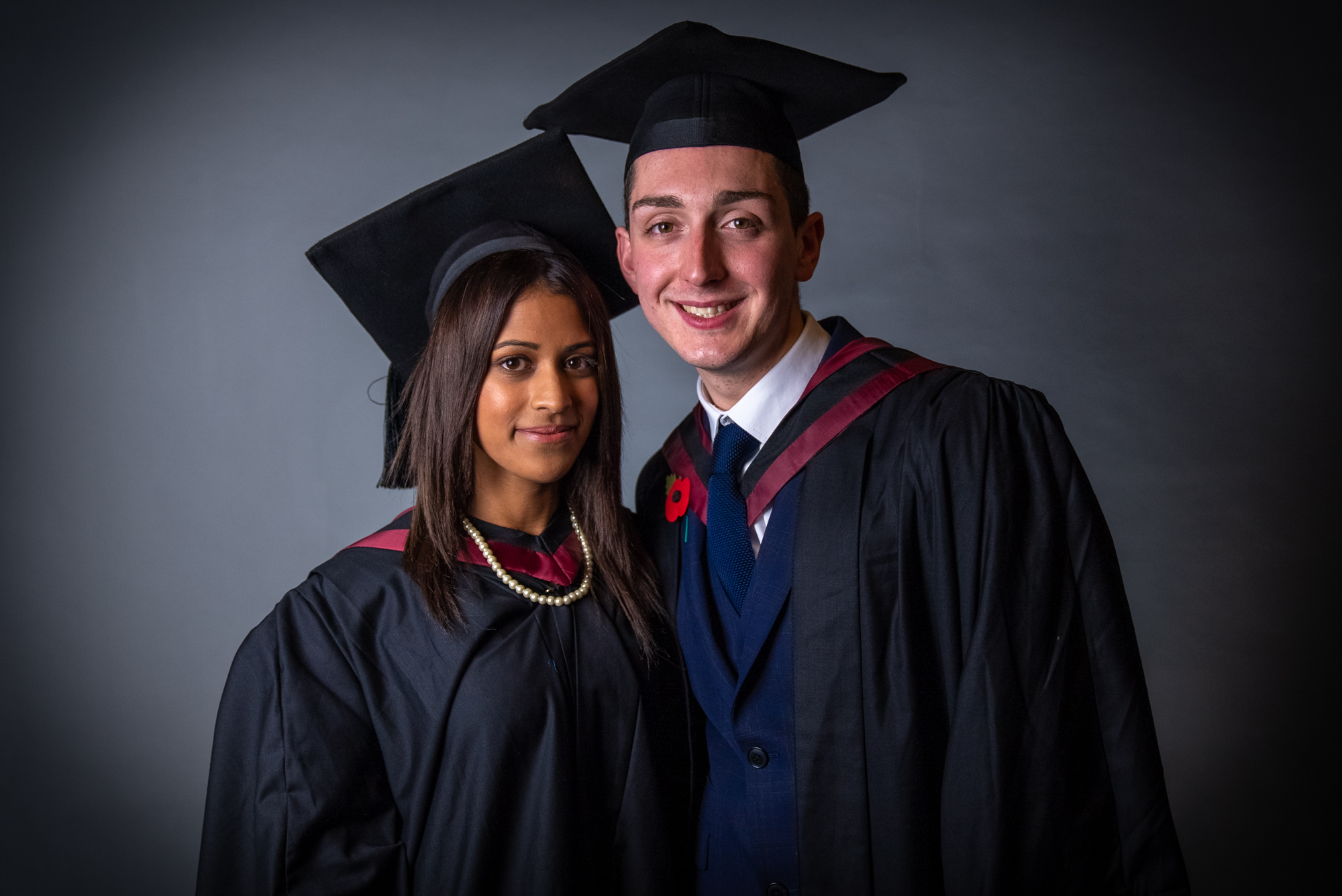 A photo of our journalism trainees at their graduation. They are wearing cap and gowns. They are smiling for a photo. 