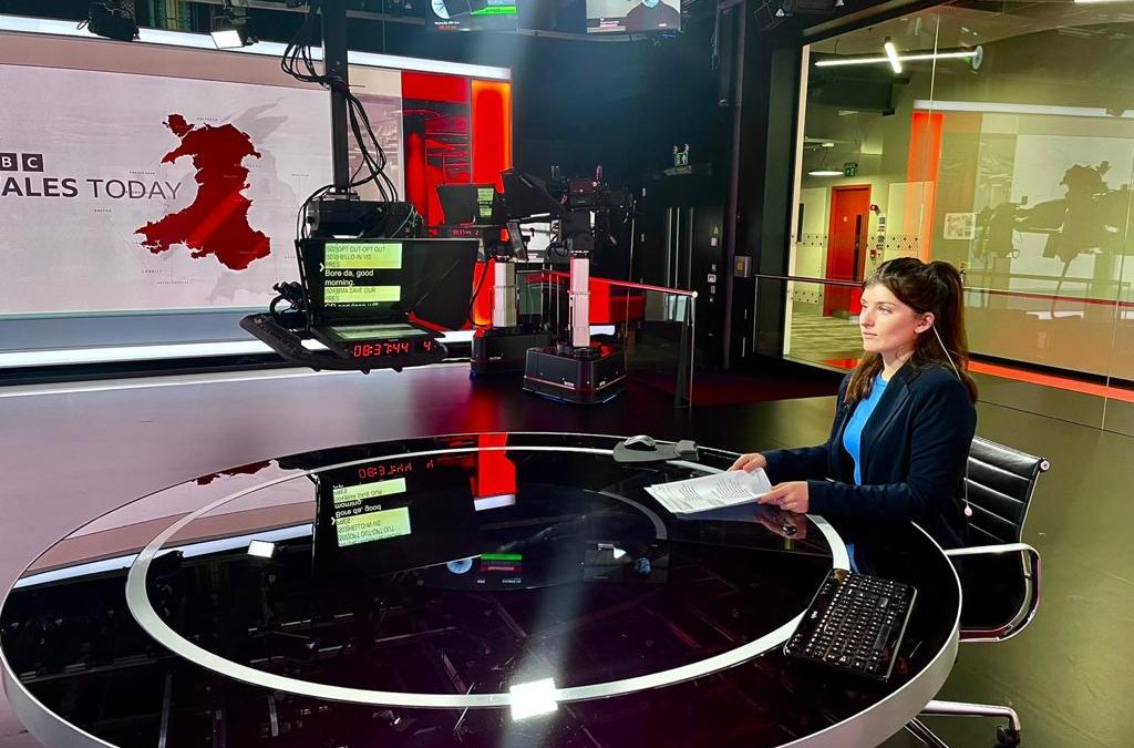 A photo of Cymbeline Young pretending to present the news in a BBC studios.