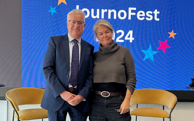News Associates deputy managing editor Graham Dudman with Sky News special correspondent Alex Crawford after her Q&A at JournoFest 2024. They are standing and smiling in front of a blue screen with the words JournoFest 2024.