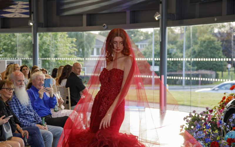 A woman in a red dress at the Cheshire Fashion Show.