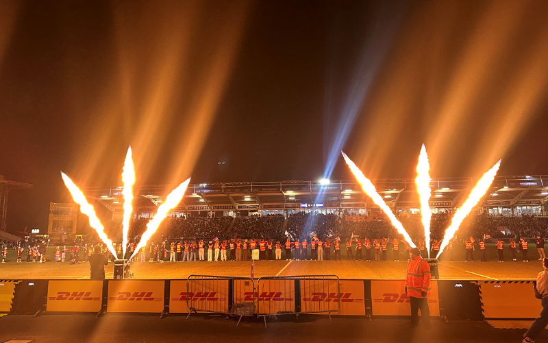 A view of the The Stoop from the stands. The players are lined up on the pitch. Fire show in front of the stand.