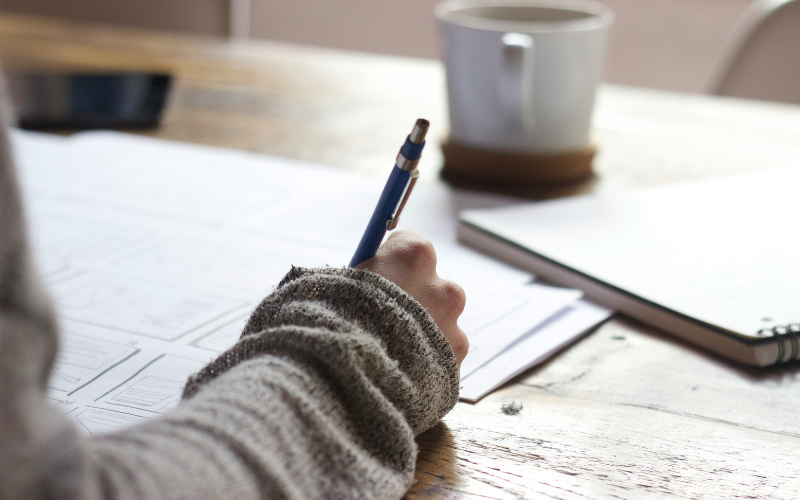 A photo of someone taking notes at a table.