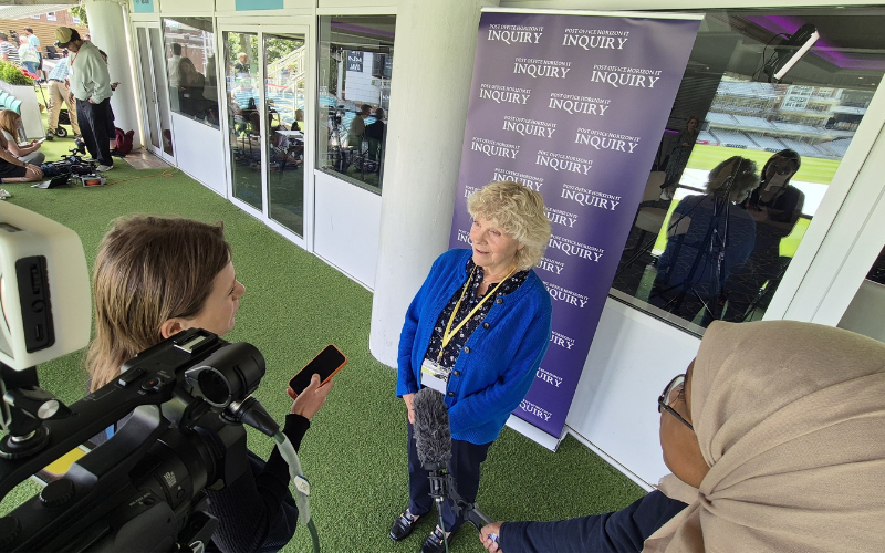 Interview at inquiry event with School of Journalism trainee Halima holding a microphone.